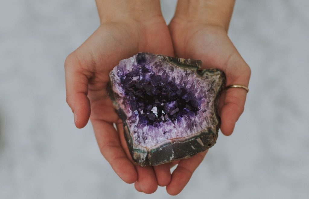 A lady holding an impressive purple geode