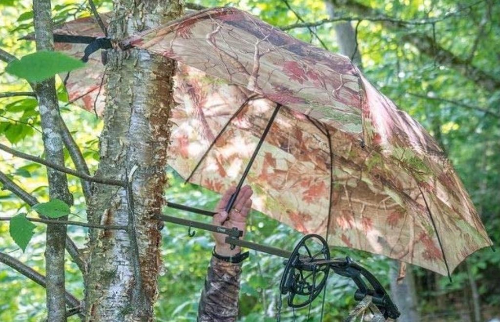 Hunter is attaching a hunting umbrella with tree