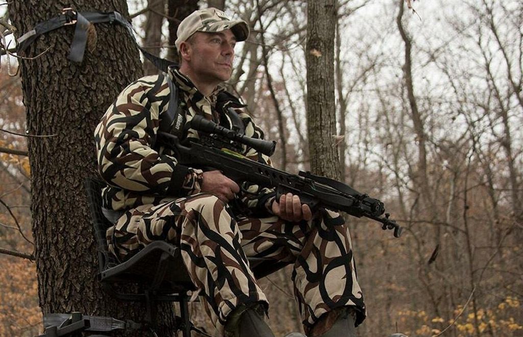 A hunting man sitting on the hang on treestand