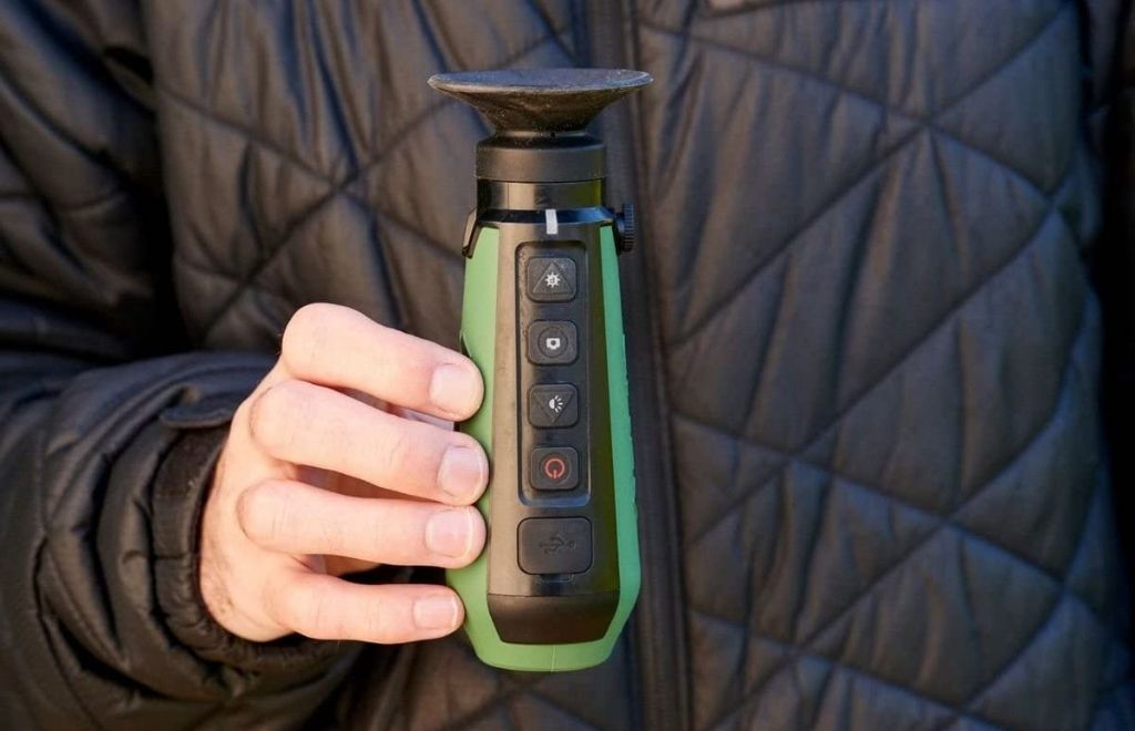 A man standing with a thermal monocular in his hands