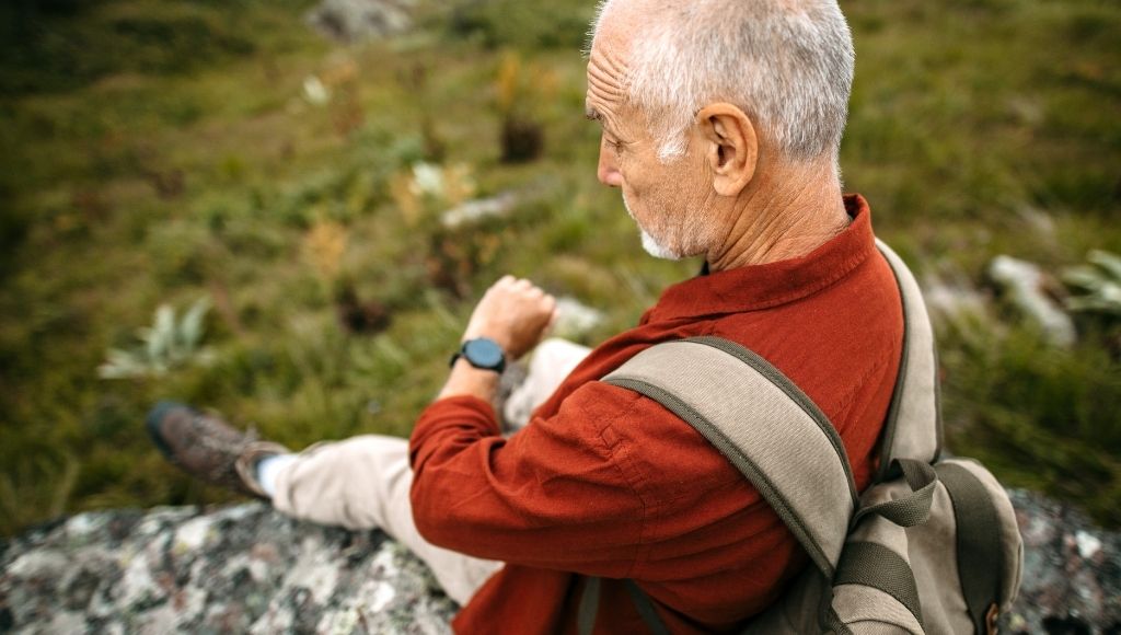 A hiking man checking smart watch