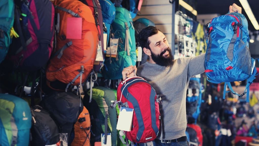 A customer examining biking backpacks in sports store