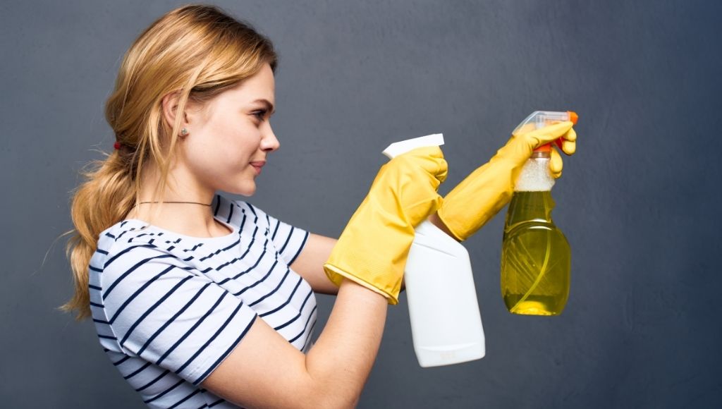 Woman holding cleaning supplies with detergent