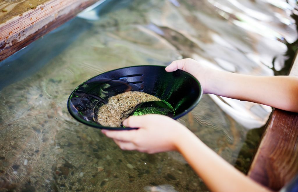 A man gold panning in water