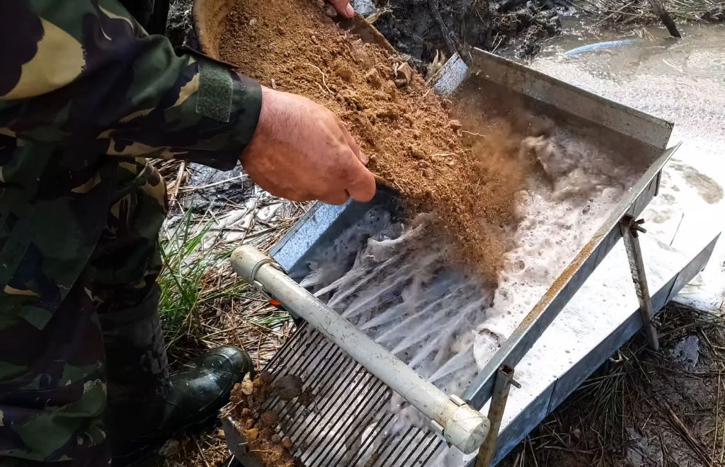 A man panning using sluice box